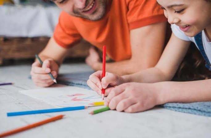 Teacher guiding a child during a creative classroom activity at Happy Scholar School in Mehdipatnam